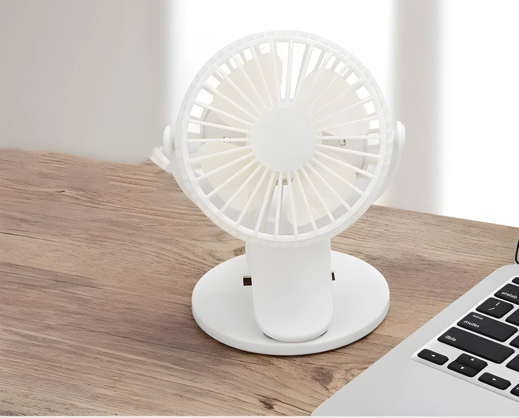 A small white USB rechargeable clip fan with plastic blades attached to a stroller handle.