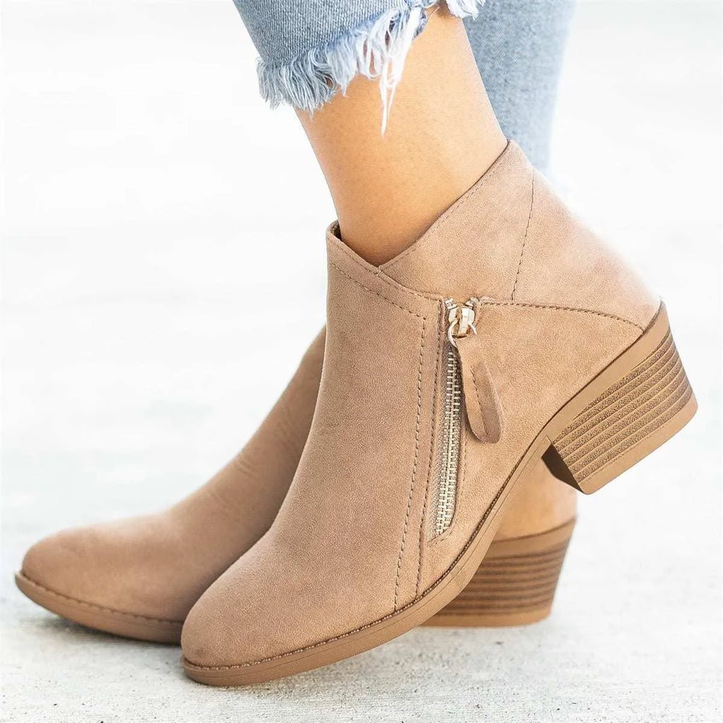 Women's blue suede Dr Martens ankle boots with a side zip and chunky heel on a white background.