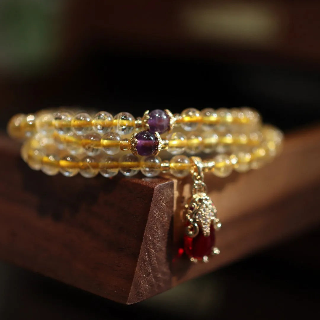 Natural Brazil gold rutilated quartz Chinese style bracelet with three gold rings and chopstick hanging detail.