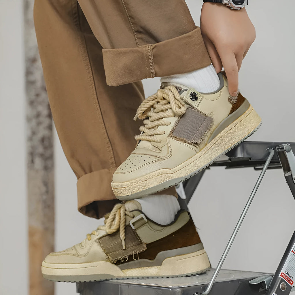Beige low-top men's skateboard sneakers with a round toe and front lace-up on a rubber sole.