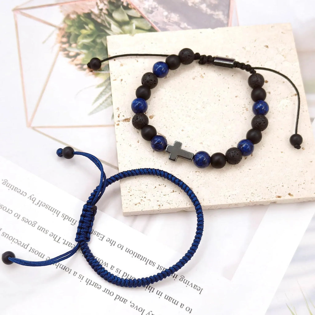 Hand-woven cross bracelet set with lapis lazuli and black matte volcanic stone beads in blue or black rope braid