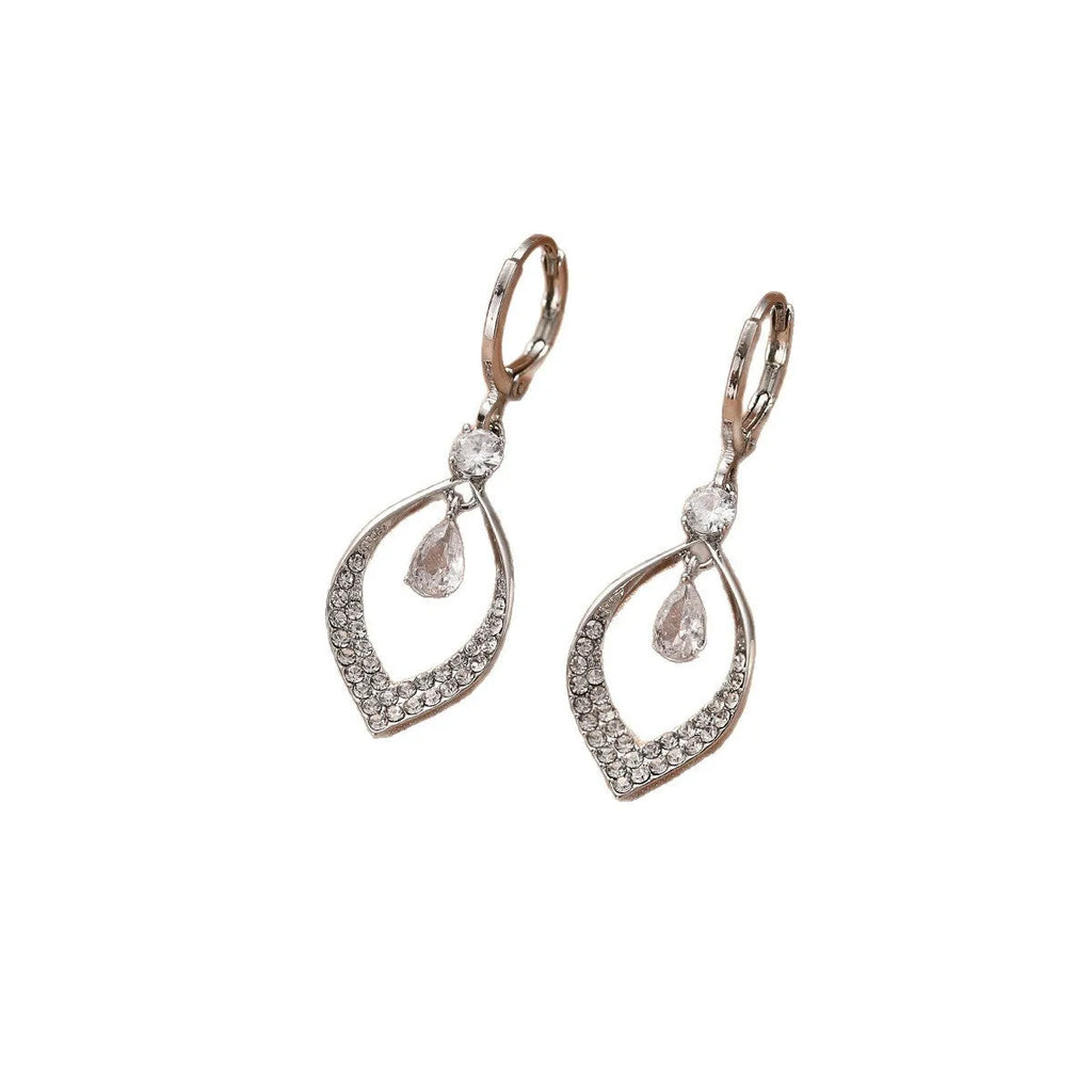 Close-up of a woman's gold-coloured water drop tassel earring with a teardrop shape and dangling details.
