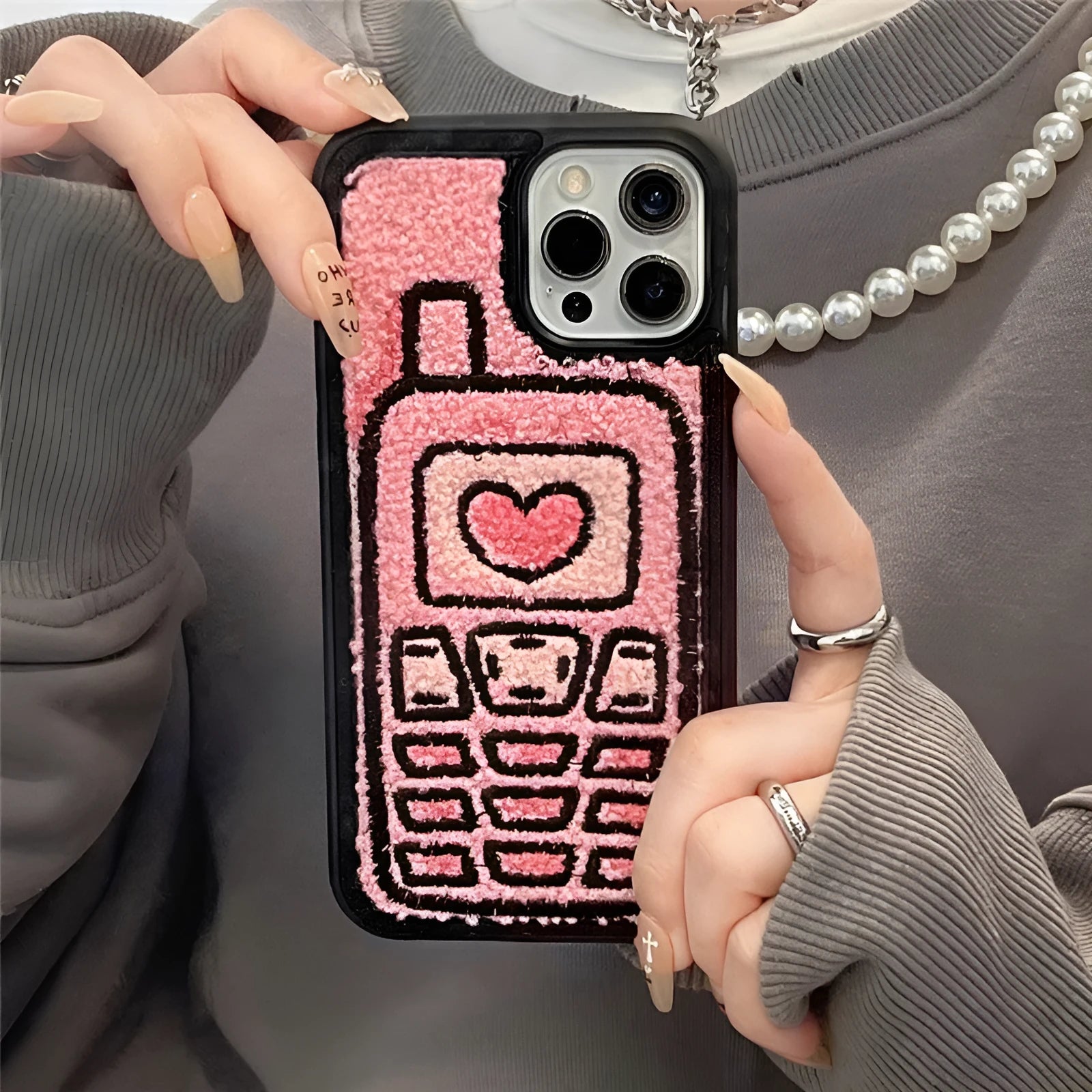 Pink towel embroidered soft TPU case for iPhone on a table.