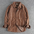 Man modelling a loose-fitting vintage striped shirt in apricot colour with long sleeves, Japanese retro style.