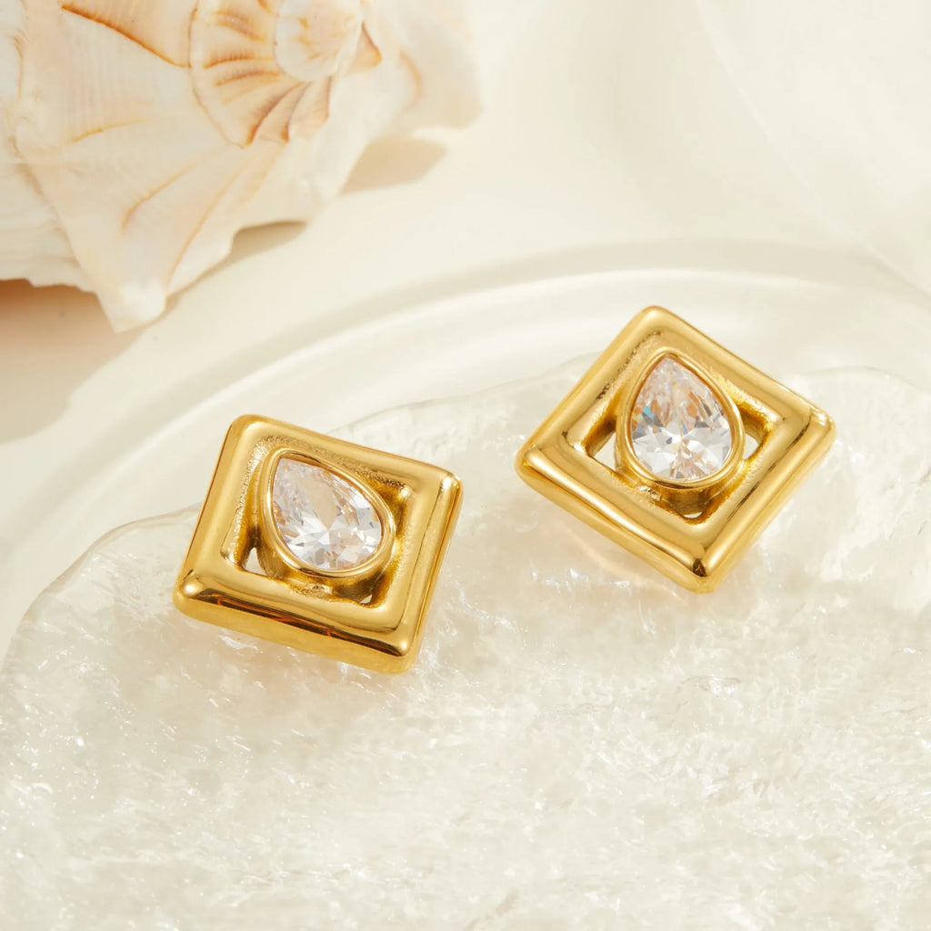 Geometric gold stud earrings with a water drop zircon stone inlaid in the centre.
