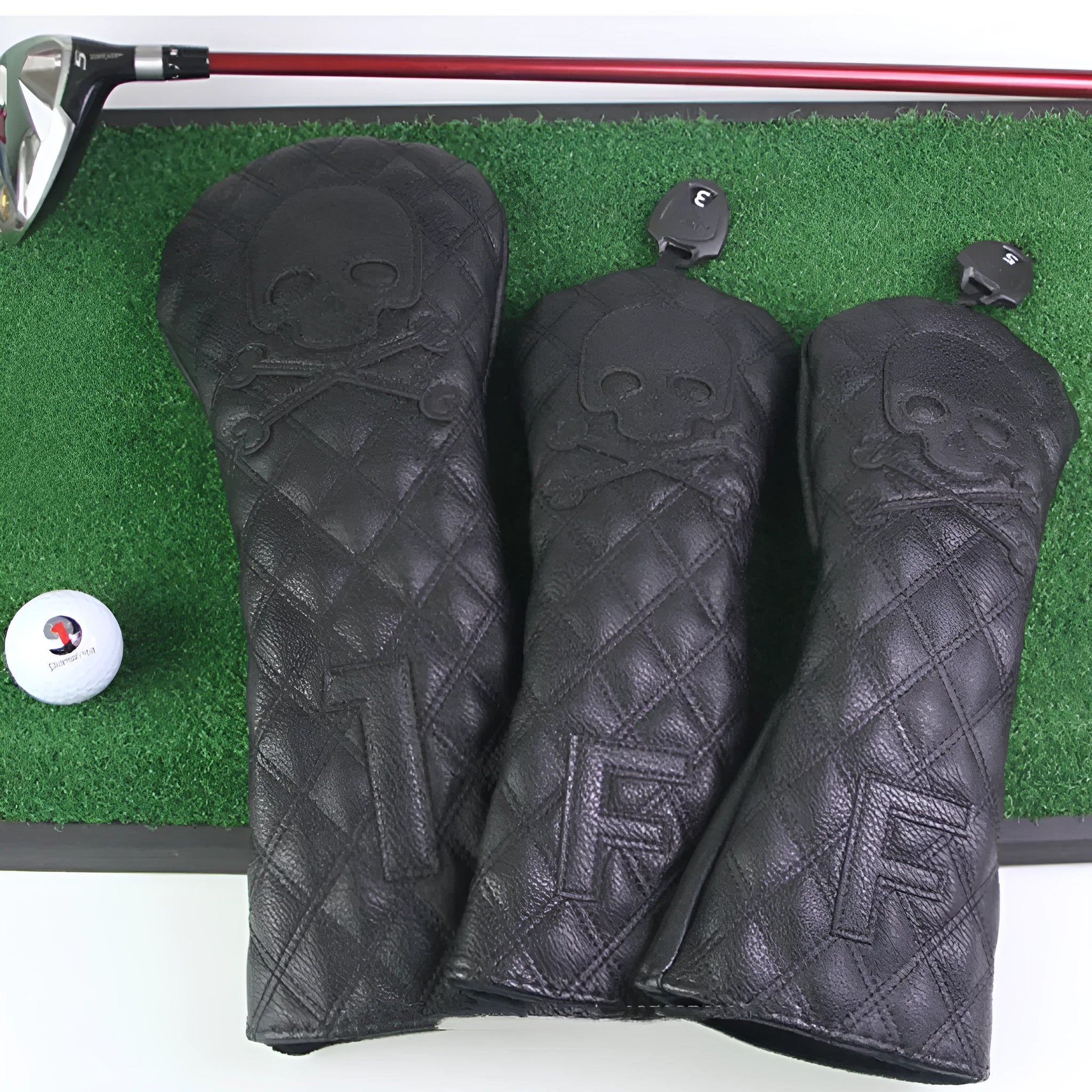 Black and white waterproof protective cover for a wooden golf pole on a green background.