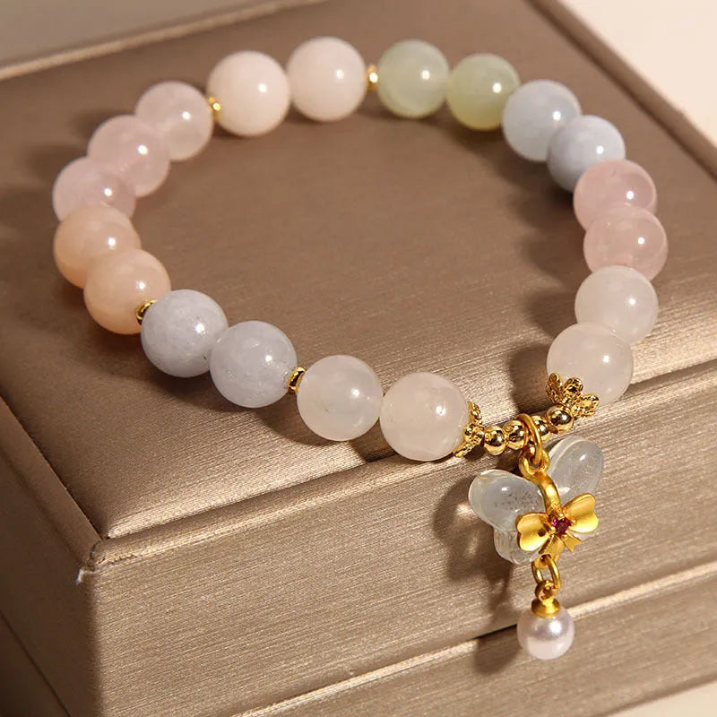 Women's adjustable crystal bracelet with a colourful morganite butterfly pendant on a white background.