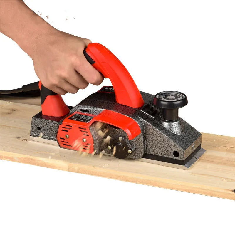 Red household desktop electric push planer tool with aluminium shell for woodworking.