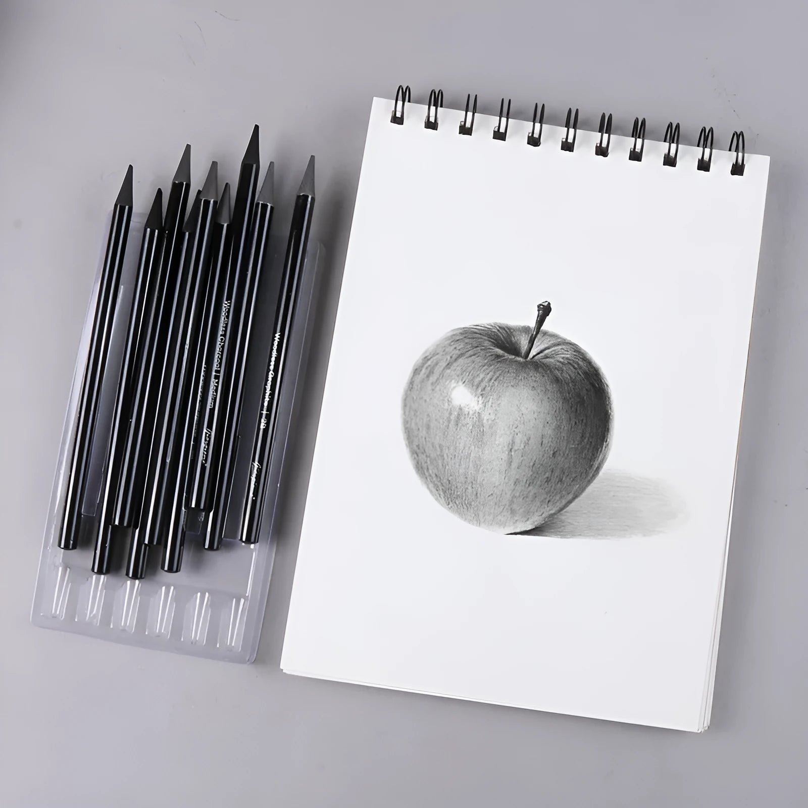 Carbonised and graphite drawing pencil set of nine in a wooden case, showing six graphite and three carbonised pencils.