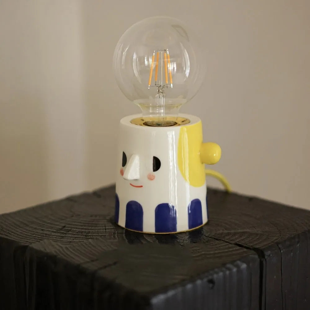Handmade ceramic table lamp with a spherical ball headlight shape on a stand.