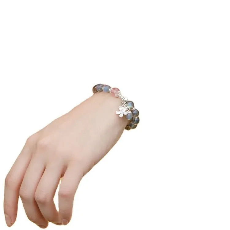 Women's bracelet with pink strawberry quartz and grey moonstone beads on a sterling silver chain with a charm.