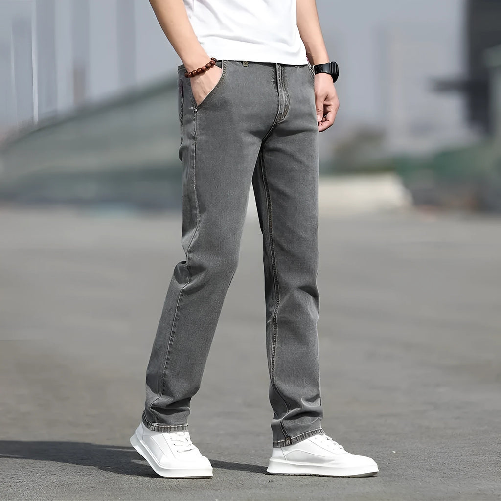 Man wearing smoky gray low-waist straight-leg jeans made from high-elasticity rabbit fur fabric.