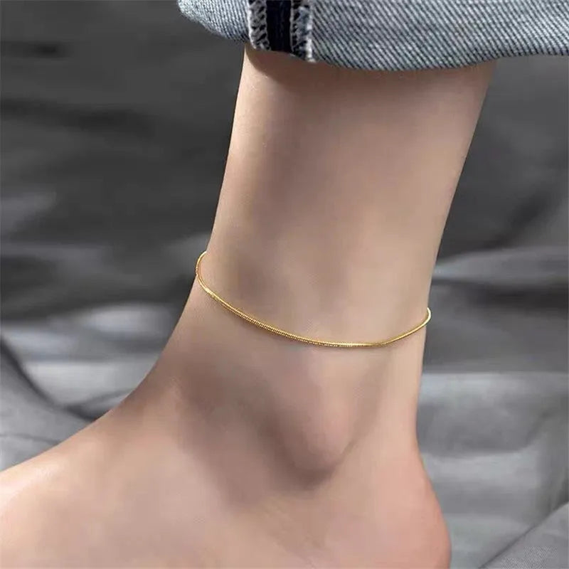 Stainless steel snake chain anklet with adjustable extender in gold colour on a white background