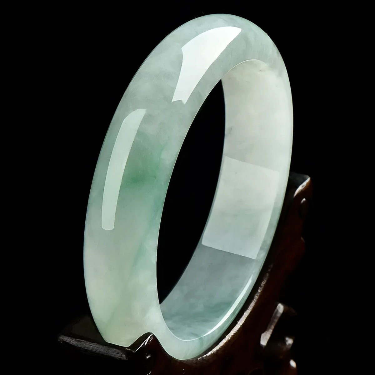 Light green jade bracelet showing natural stone colouration with size markings from 53 to 64