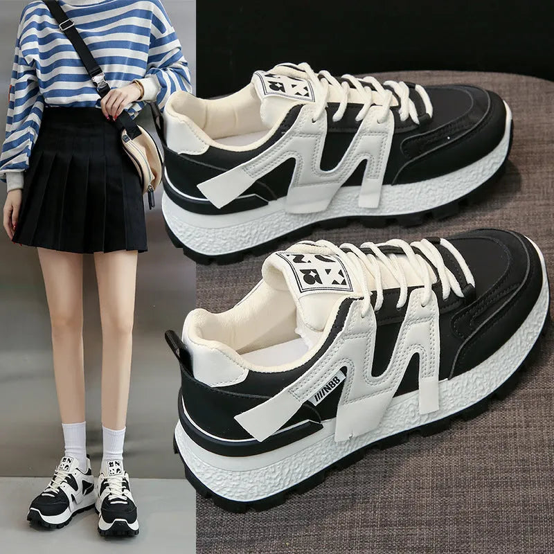 Low top unisex running sneaker in black or white with round toe and flat rubber sole.