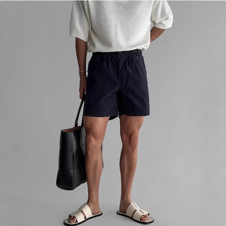 Men's loose-fit cotton sports shorts in black, shown on a model.