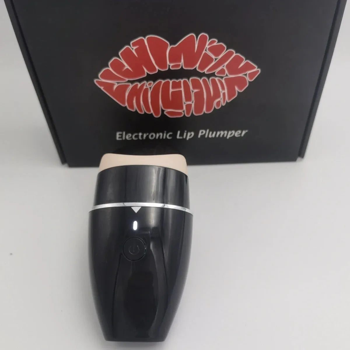 Black and white electric silicone lip plumper device with USB charging cable.