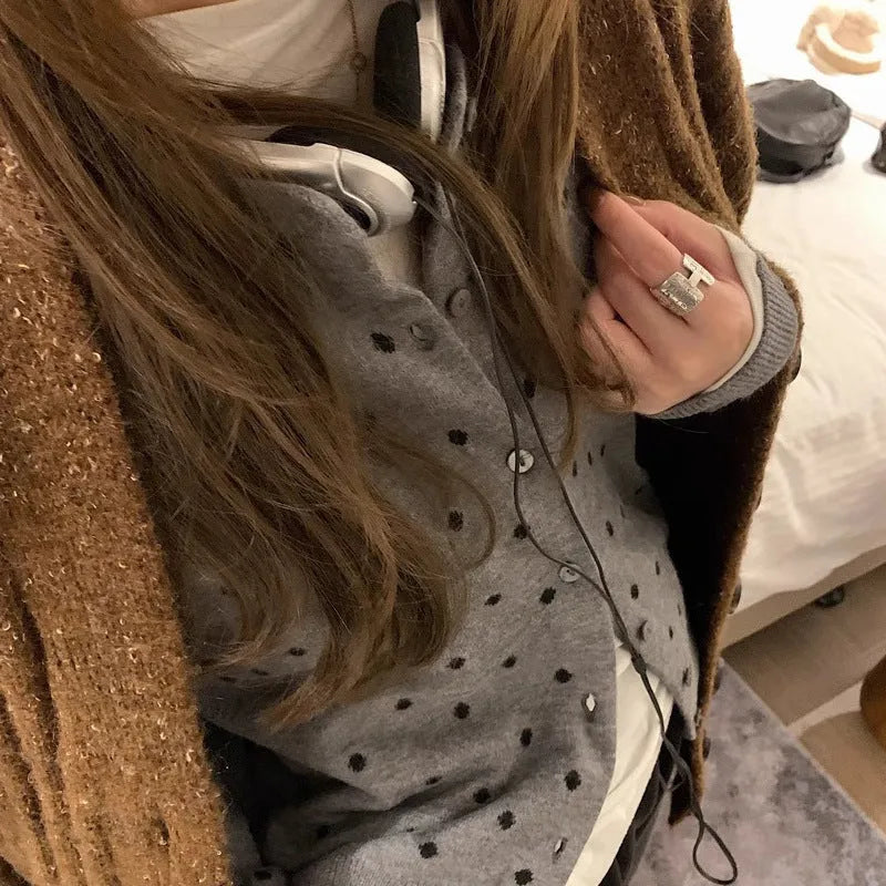 Women's loose-fit gray dot patterned knitted cardigan in black, showcasing crocheted flower detail.