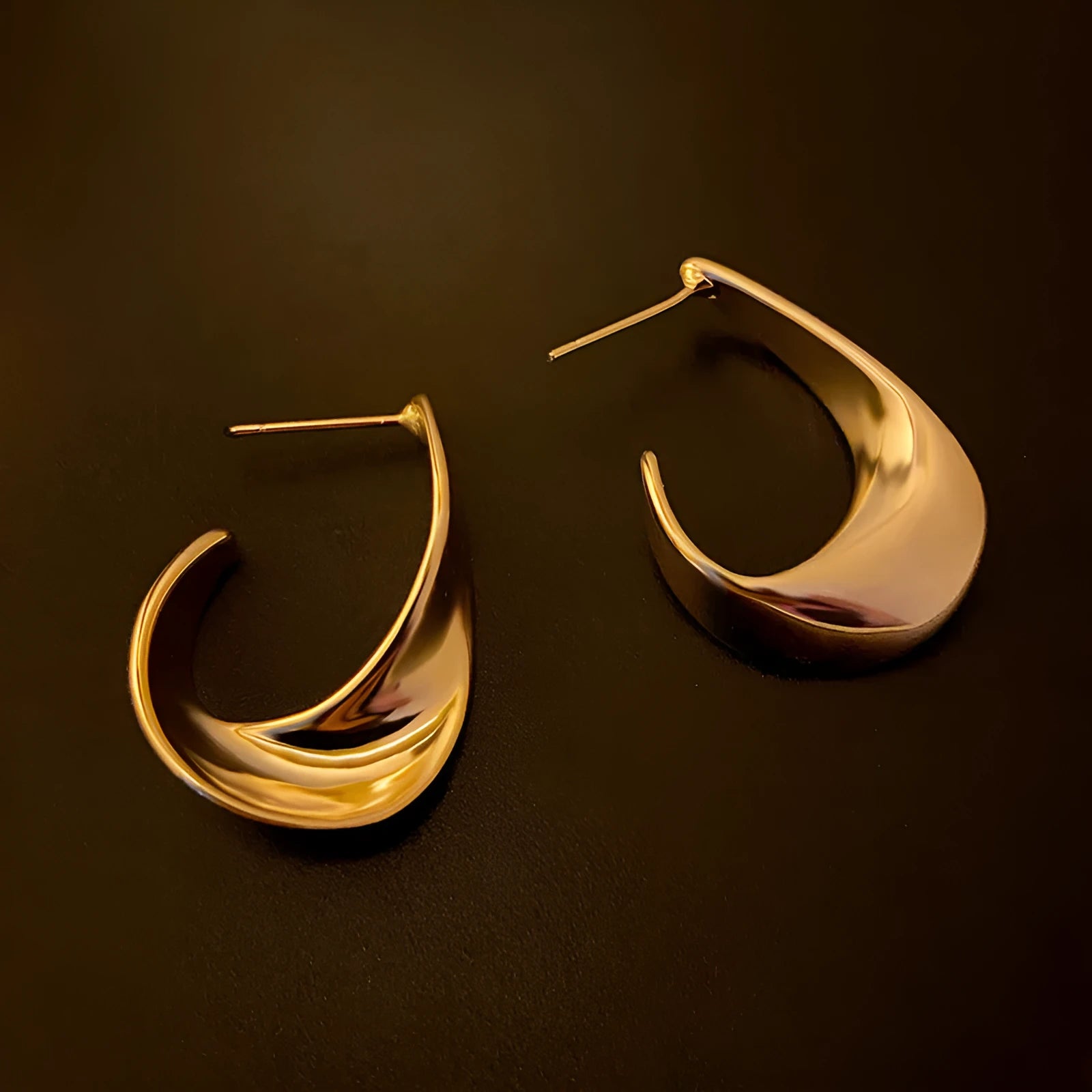 Twisted geometric metal earrings with circular elements in gold or silver electroplated finish
