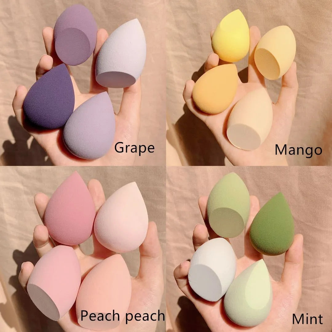Four makeup egg sponges in grape, mango, mint, and peach peach colours arranged in a box