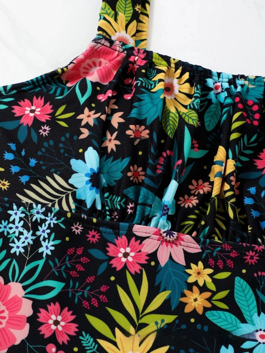Women's floral print one-piece full-bed swimsuit on a hanger, showing front and back.