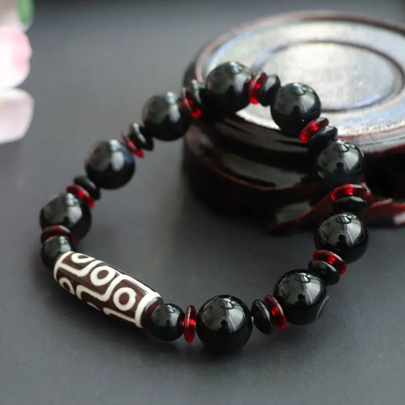 Hand-woven black agate Dzi bracelet with geometric 11mm beads on wrist