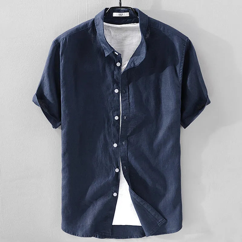 Man wearing a light blue loose fit short sleeve linen shirt for casual summer wear.