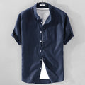 Man wearing a light blue loose fit short sleeve linen shirt for casual summer wear.