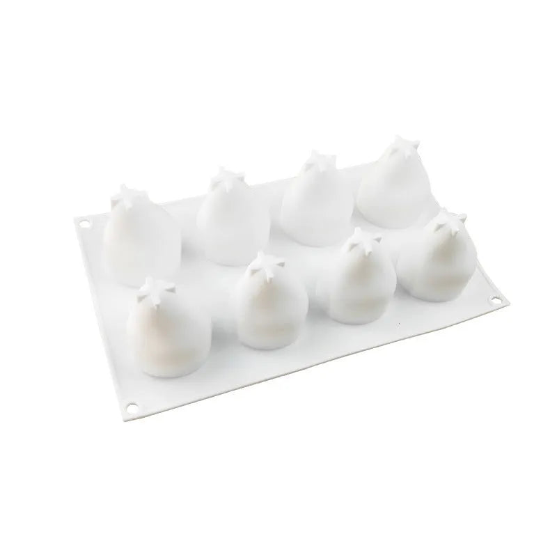 Silicone baking mould with six cavities shaped like pineapples, pine cones, and pears on a kitchen worktop.