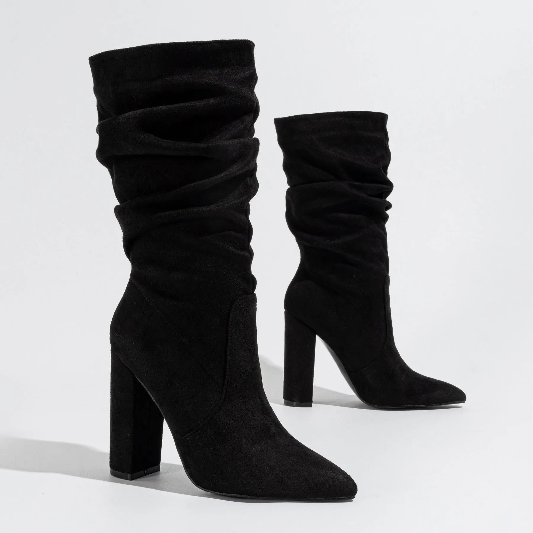 Women's black suede chunky heel boots with pointed toe and middle calf length.