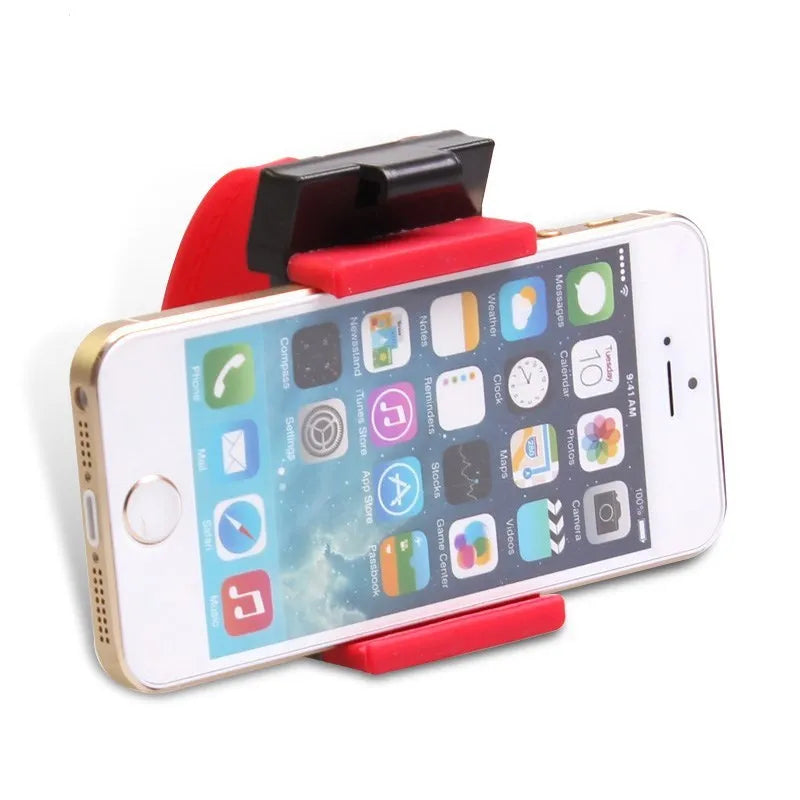 Black steering wheel phone mount holder clipped to a car wheel, holding a large smartphone.