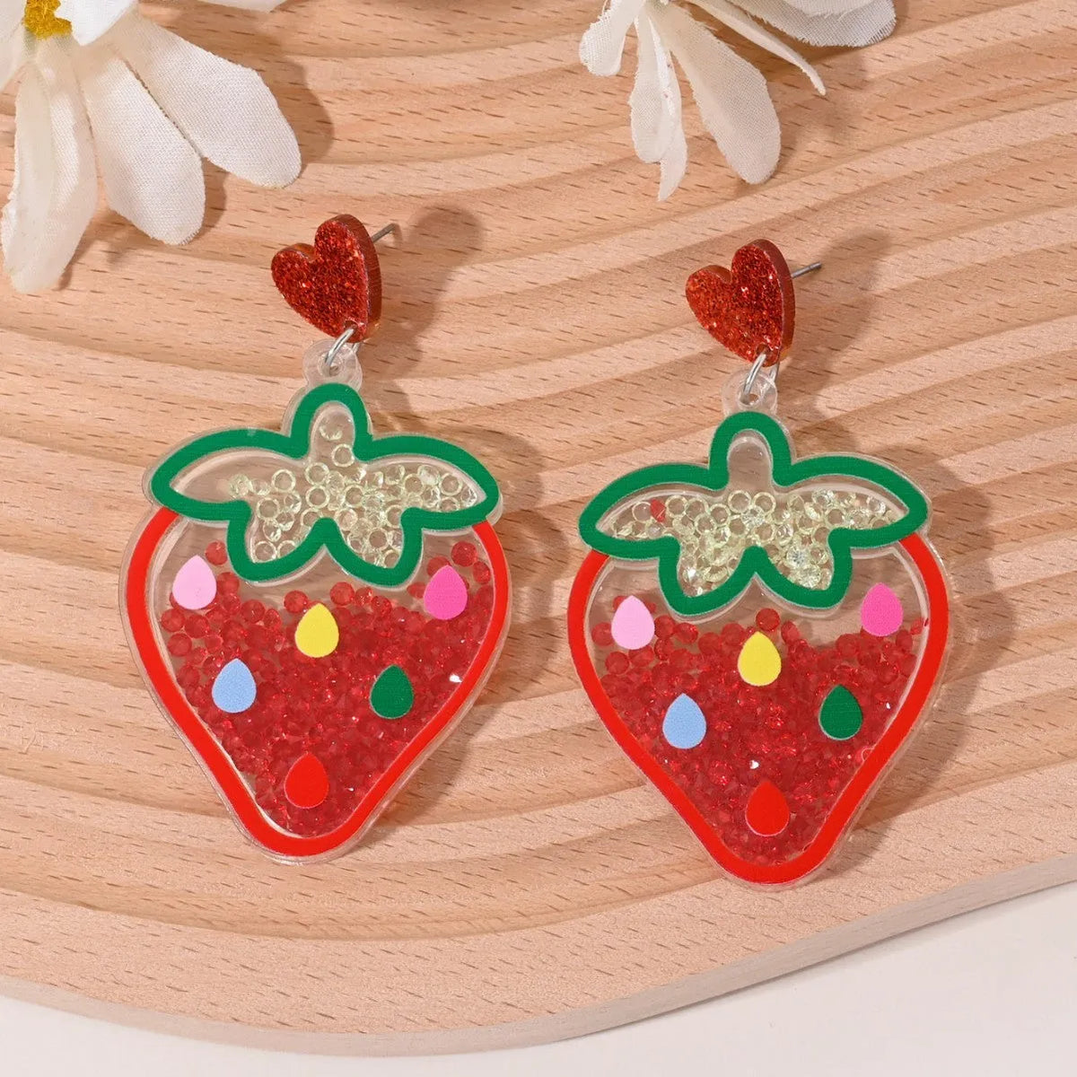 Acrylic drop earrings shaped like a strawberry, cherry, watermelon, pineapple, cake, ice cream, and coconut tree on a white background.