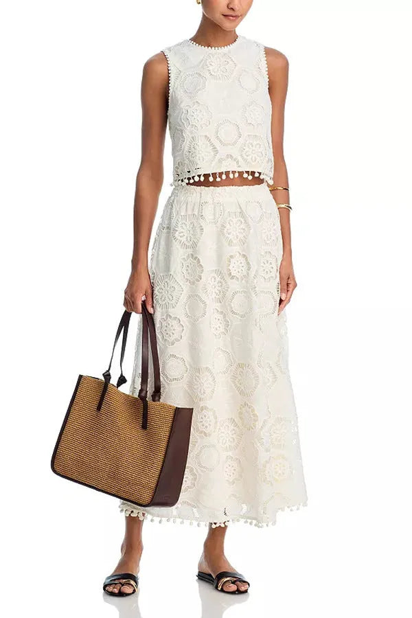 White women's retro style suit set with sleeveless top and embroidered long skirt.