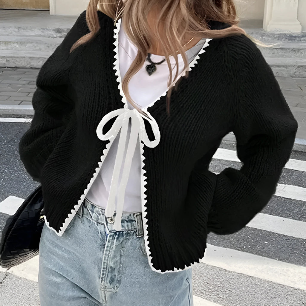 Women's grey lace-up cardigan with crocheted flowers on the front and loose long sleeves.