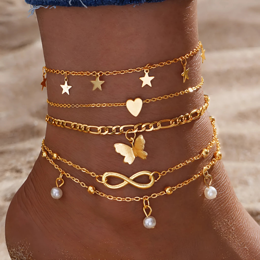 Set of four women's alloy anklets with butterfly, pearl, and heart charms.