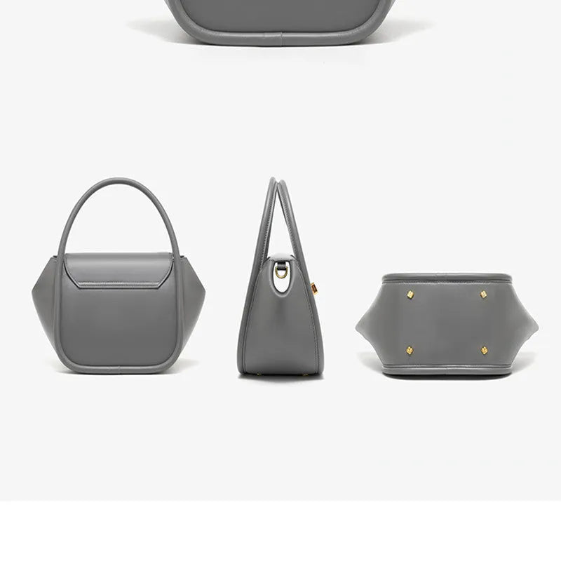 Women's winged leather handbag with cross-body strap in blue, showing latch closure and buckle detail.