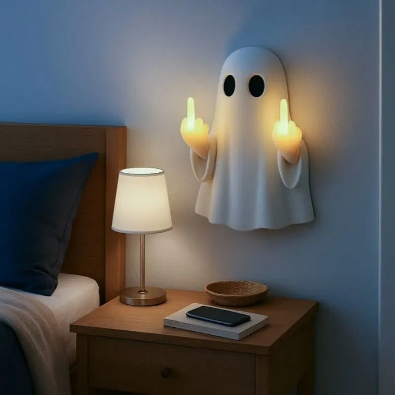 White ghost statue night lamp with LED light on a dark table.