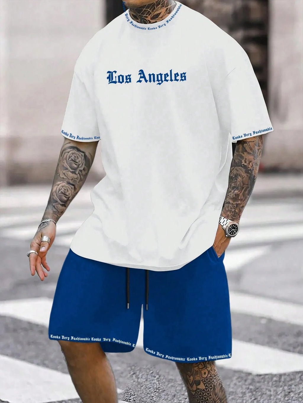 Man wearing a grey short sleeve athletic top and matching shorts from a polyester sportswear set.