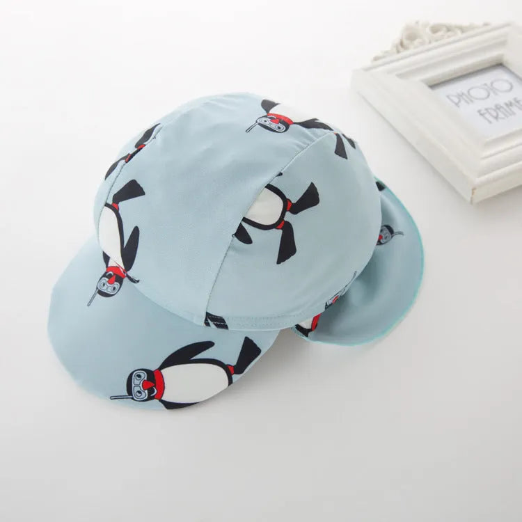 Boy's penguin print long sleeve one-piece swimsuit with matching swimming cap.