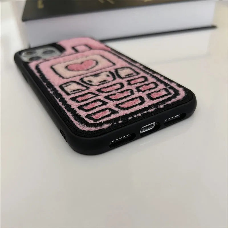 Pink towel embroidered soft TPU case for iPhone on a table.