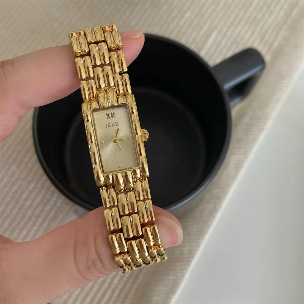 Women's antique-style bracelet watch with small white dial on a silver strap, showing butterfly buckle.