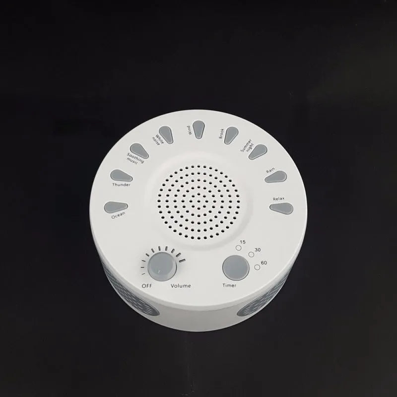 White noise sleep machine with volume knob, showing white colour option, beside USB cable on table