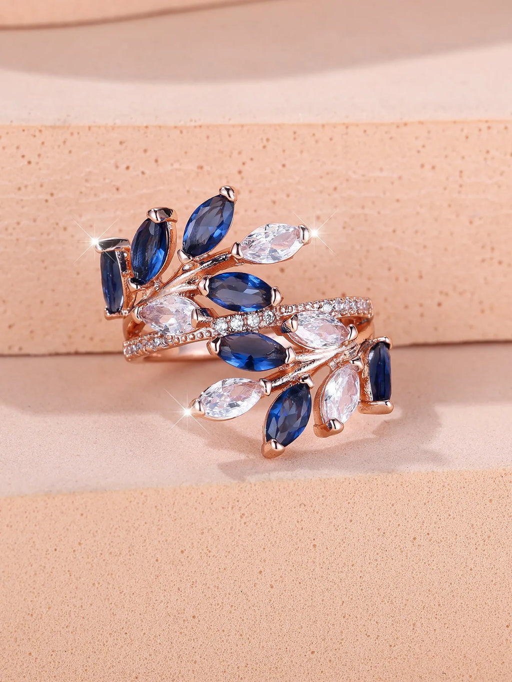Copper leaf-shaped fashion ring with zircon details and an adjustable opening, shown in a rose gold finish.