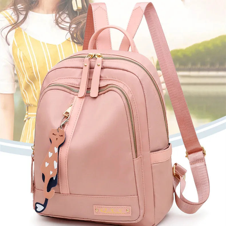 Women's black casual nylon backpack with double straps and a front pocket, shown next to a pink version.