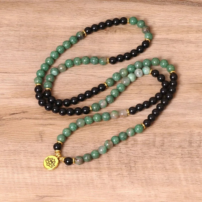 Green and black elastic beaded alloy bracelet on wrist showing natural style design