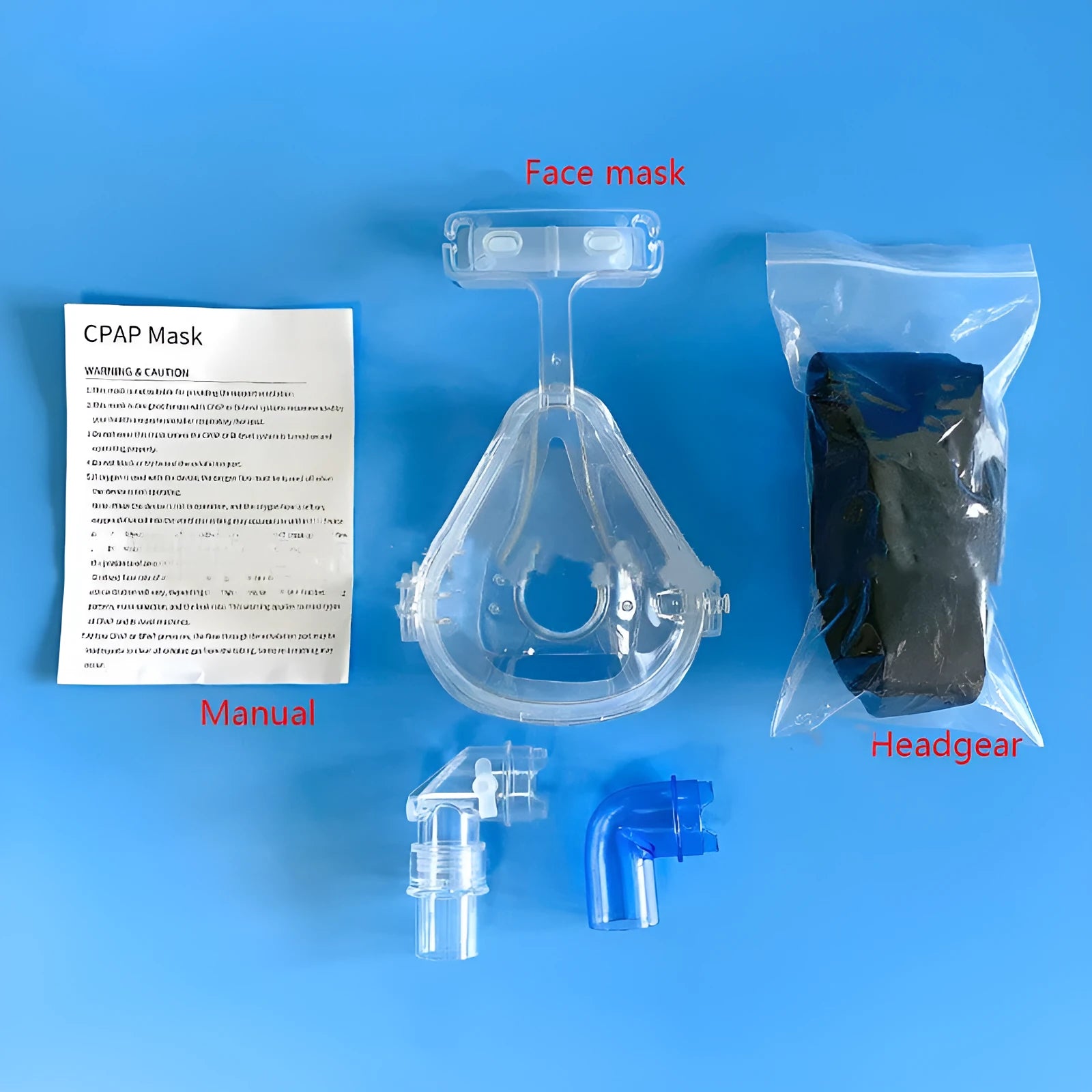Transparent silicone CPAP breathing mask with headband and two adapter elbows on a white background.