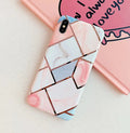 Flexible silicone mobile phone case for various iPhone models on a table.