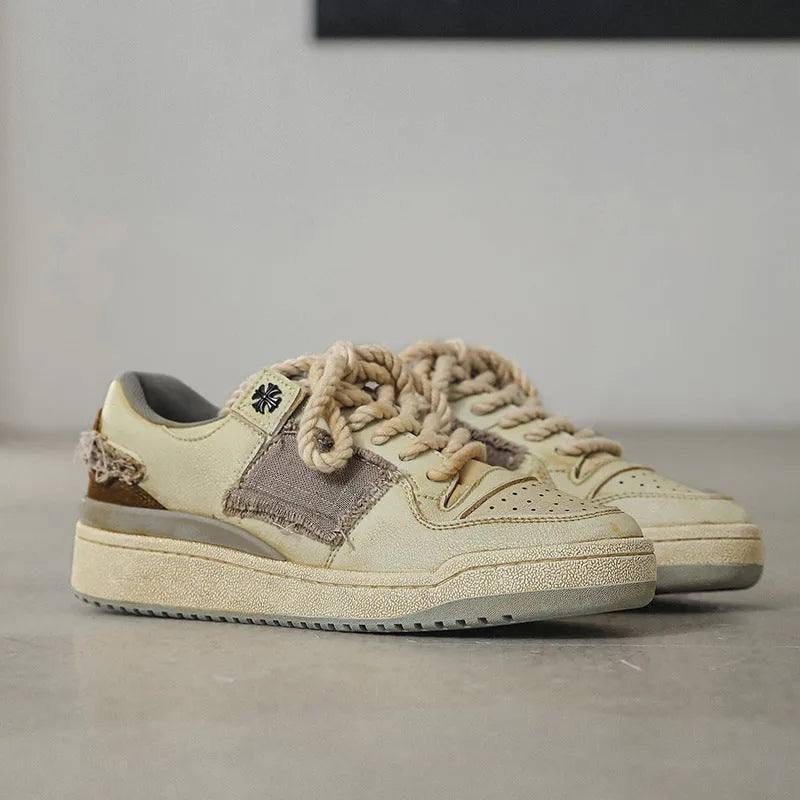 Beige low-top men's skateboard sneakers with a round toe and front lace-up on a rubber sole.