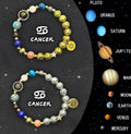 Set of two natural stone beaded bracelets with zodiac sign designs on a flat surface.