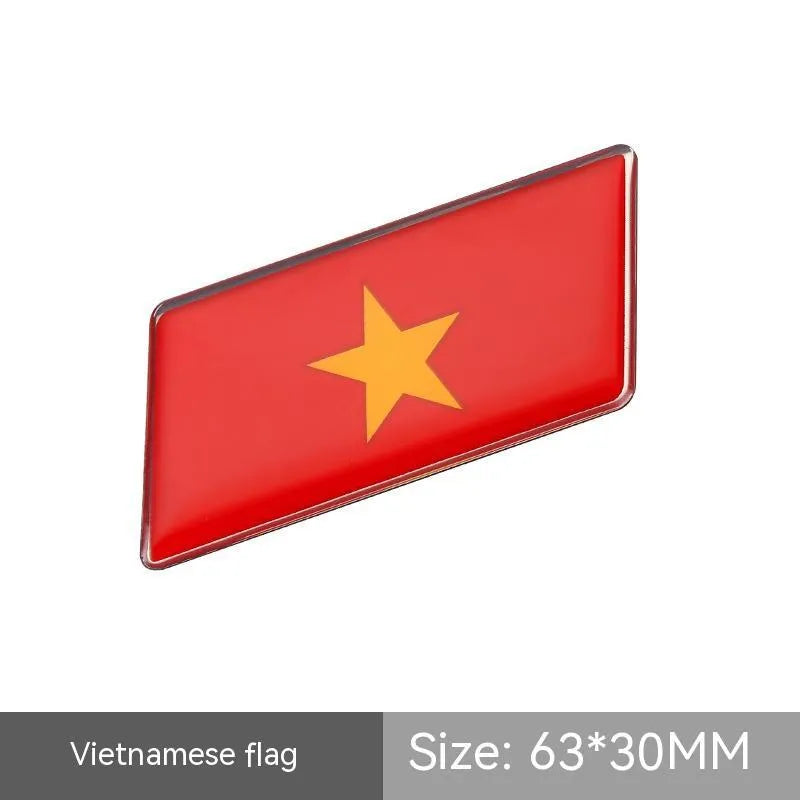 Aluminium national flag car sticker in a parallelogram shape measuring 6.3 by 3 centimetres.